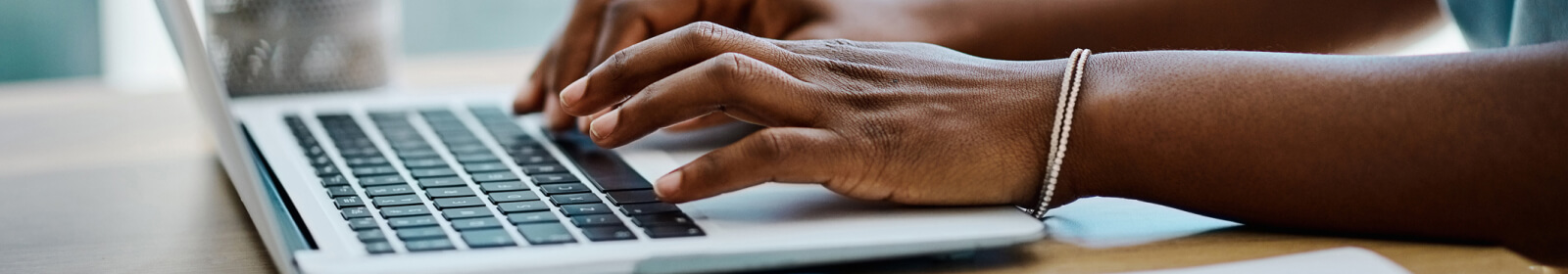 Hands typing on a laptop